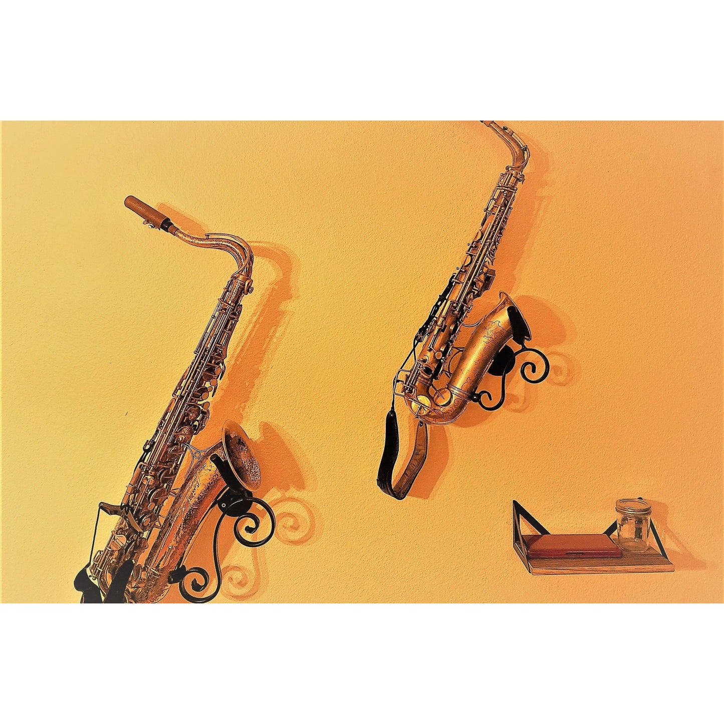 grainy customer made picture of two saxophones in bespoke saxophone stands made by Locoparasaxo on yellow wall