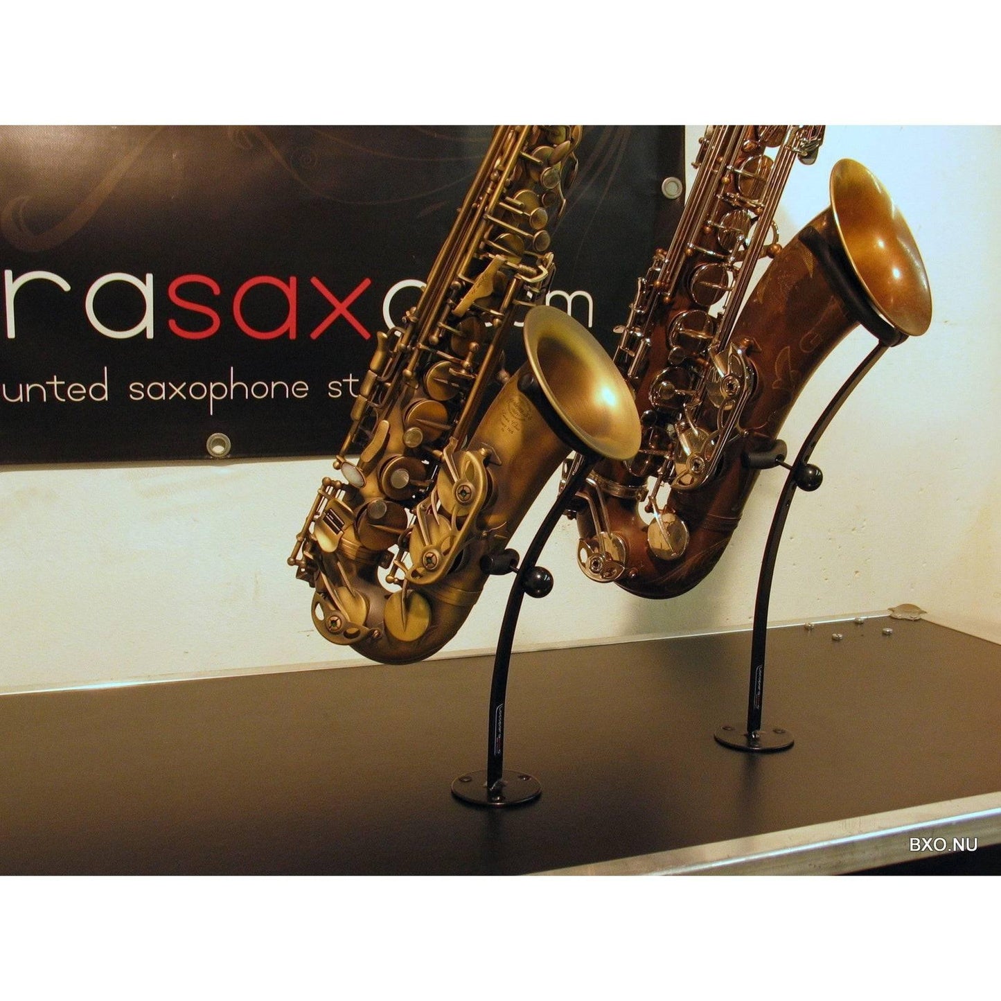 trade show pic of 2 desktop saxophones in a stand designed for exhibits and playing rooms by Locoparasaxo 