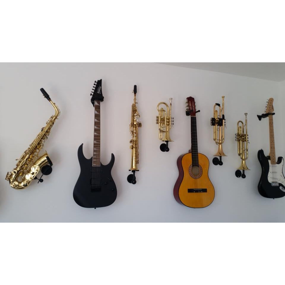 Livingroom wall with many different musical instruments mounted on the wall.